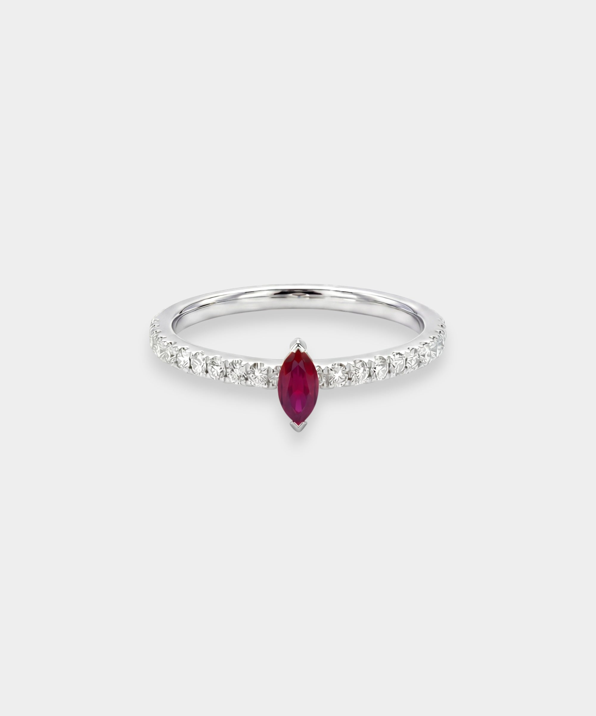 Ring with a red ruby gemstone and diamond accents on a white background