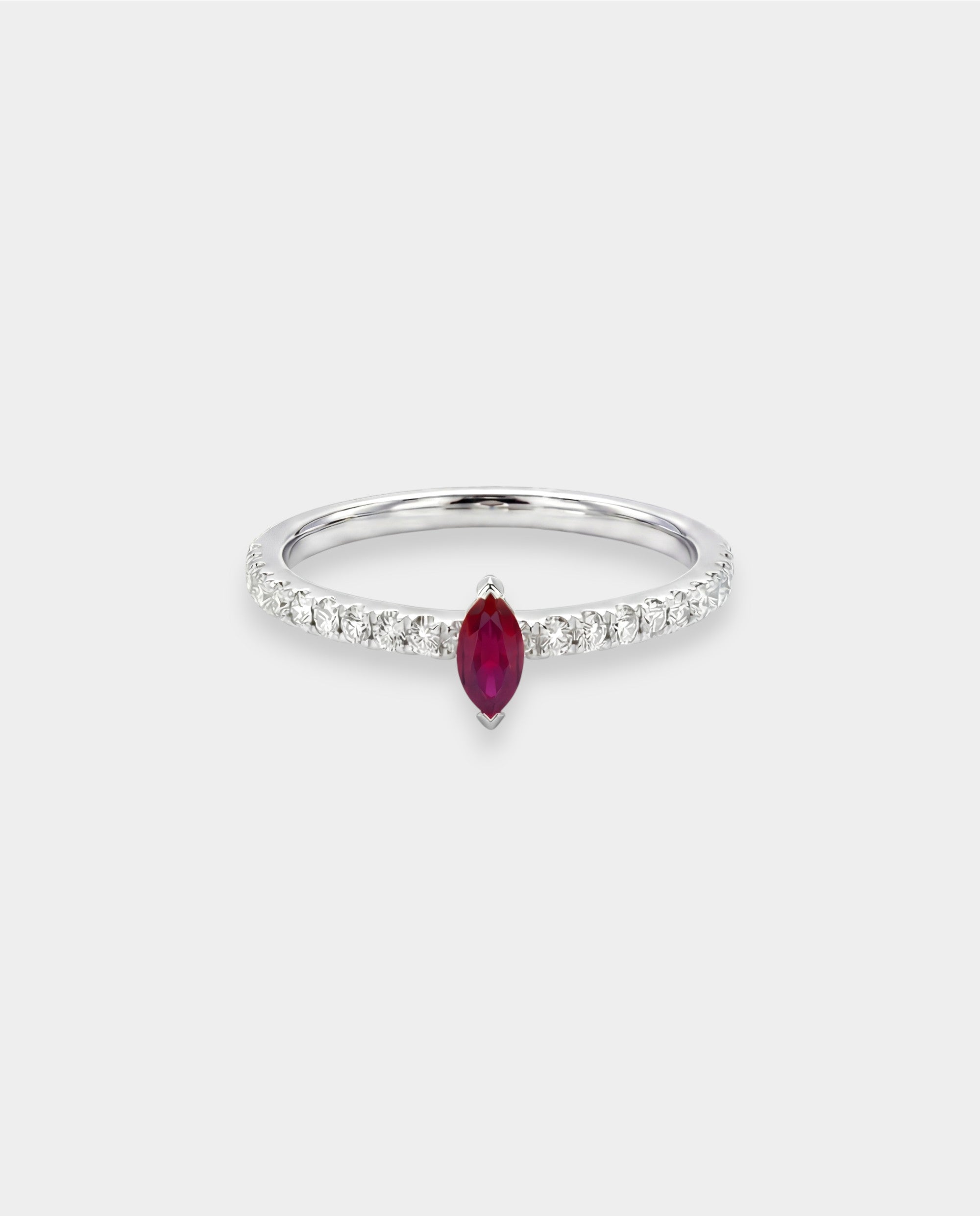 Ring with a red ruby gemstone and diamond accents on a white background