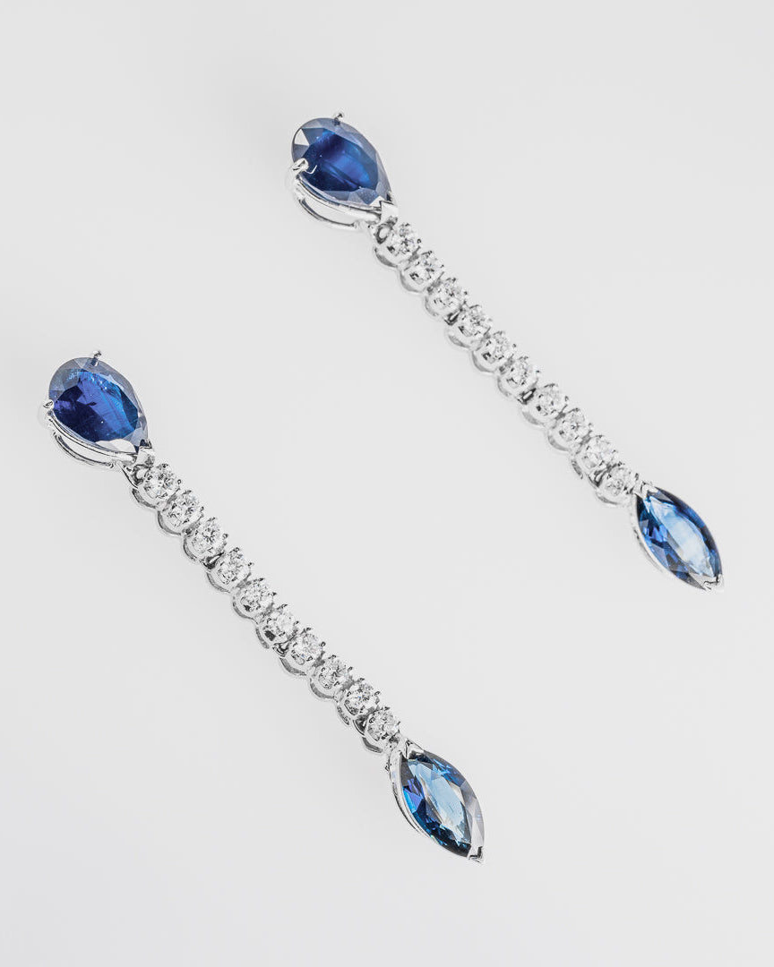 Pair of earrings with sapphires and clear diamonds on a white background