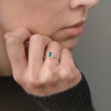 Ring with a sapphire and diamond accents on a white background