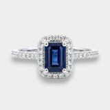 Ring with a deep blue sapphire and diamond accents on a white background