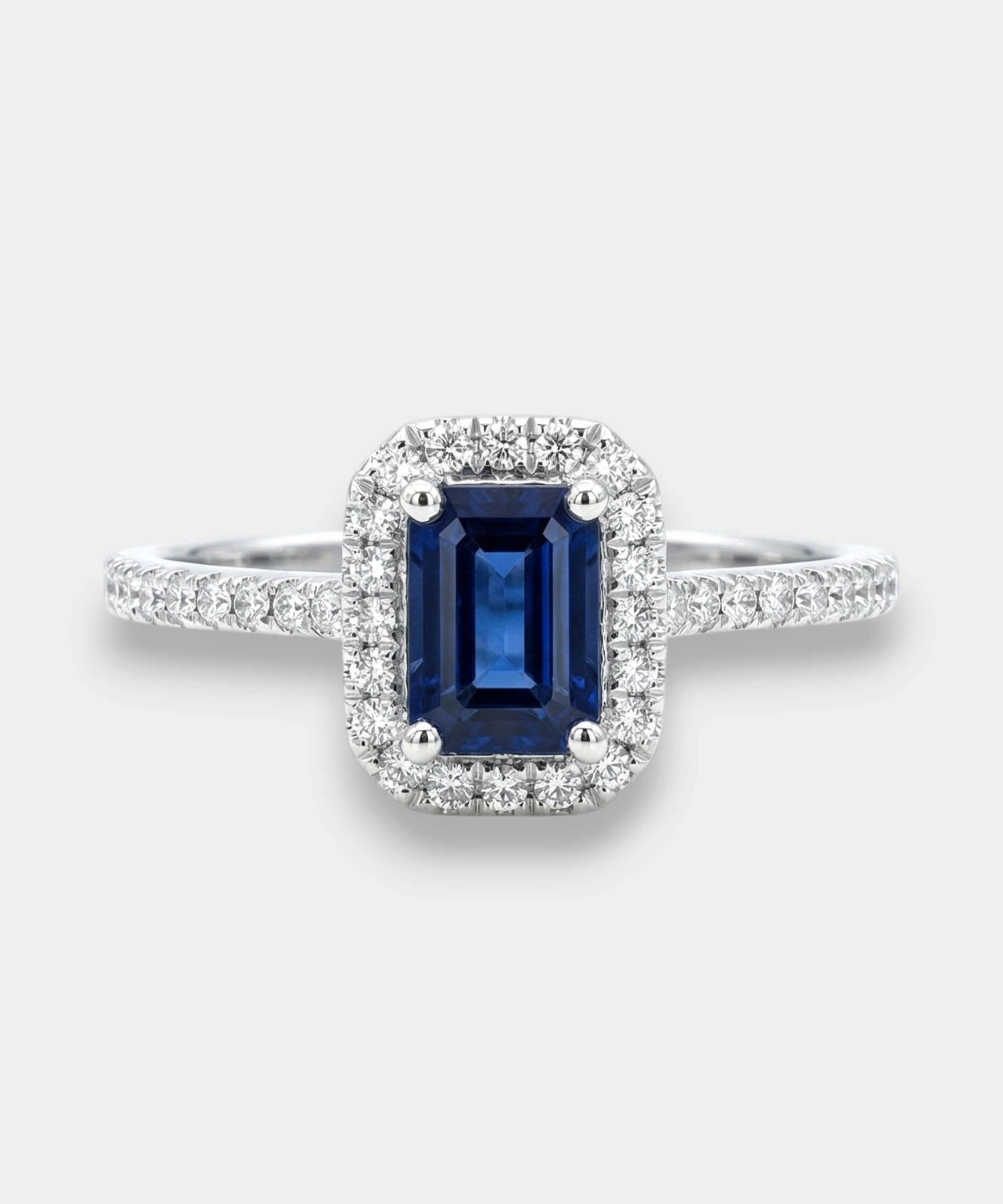 Ring with a deep blue sapphire and diamond accents on a white background