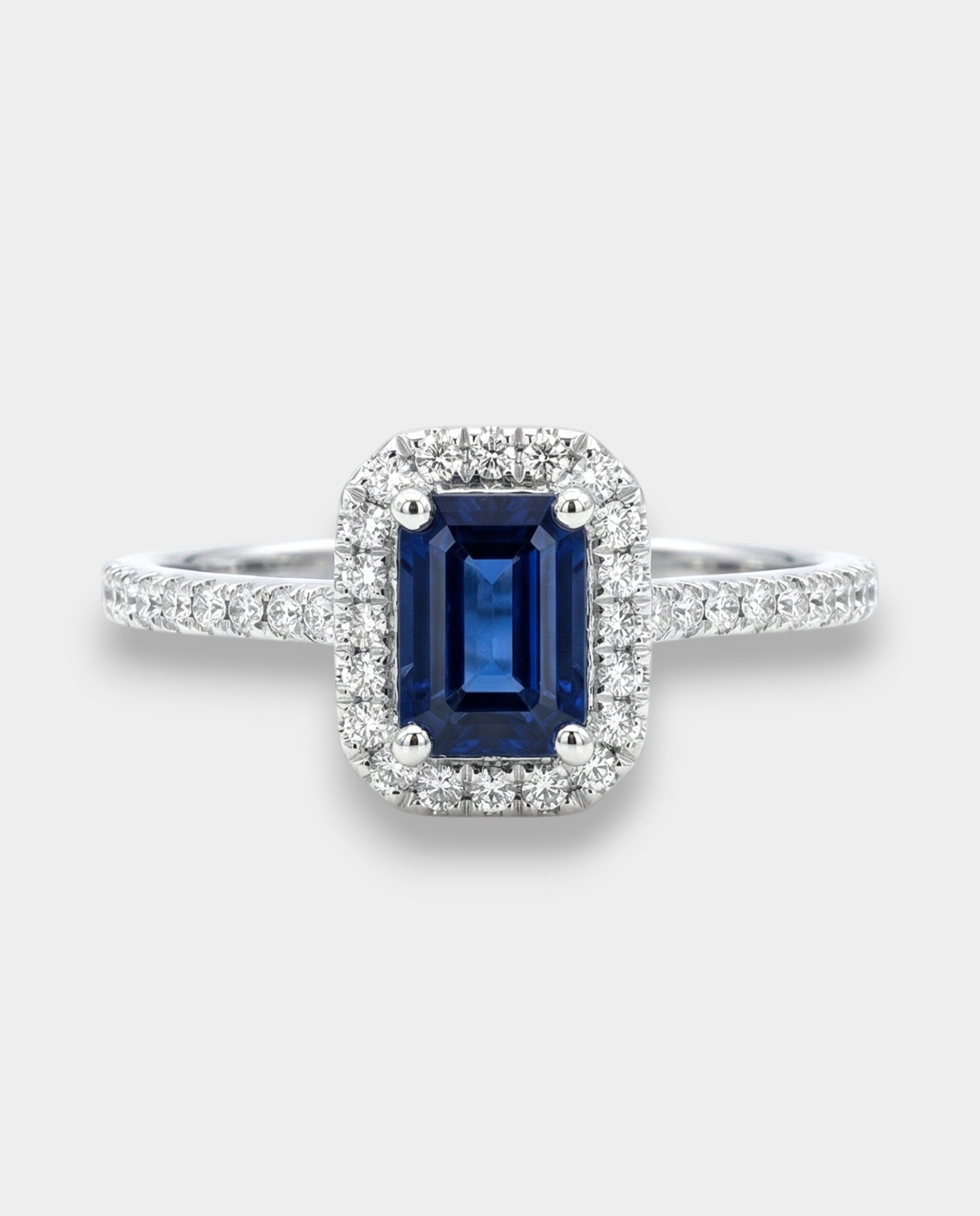 Ring with a deep blue sapphire and diamond accents on a white background