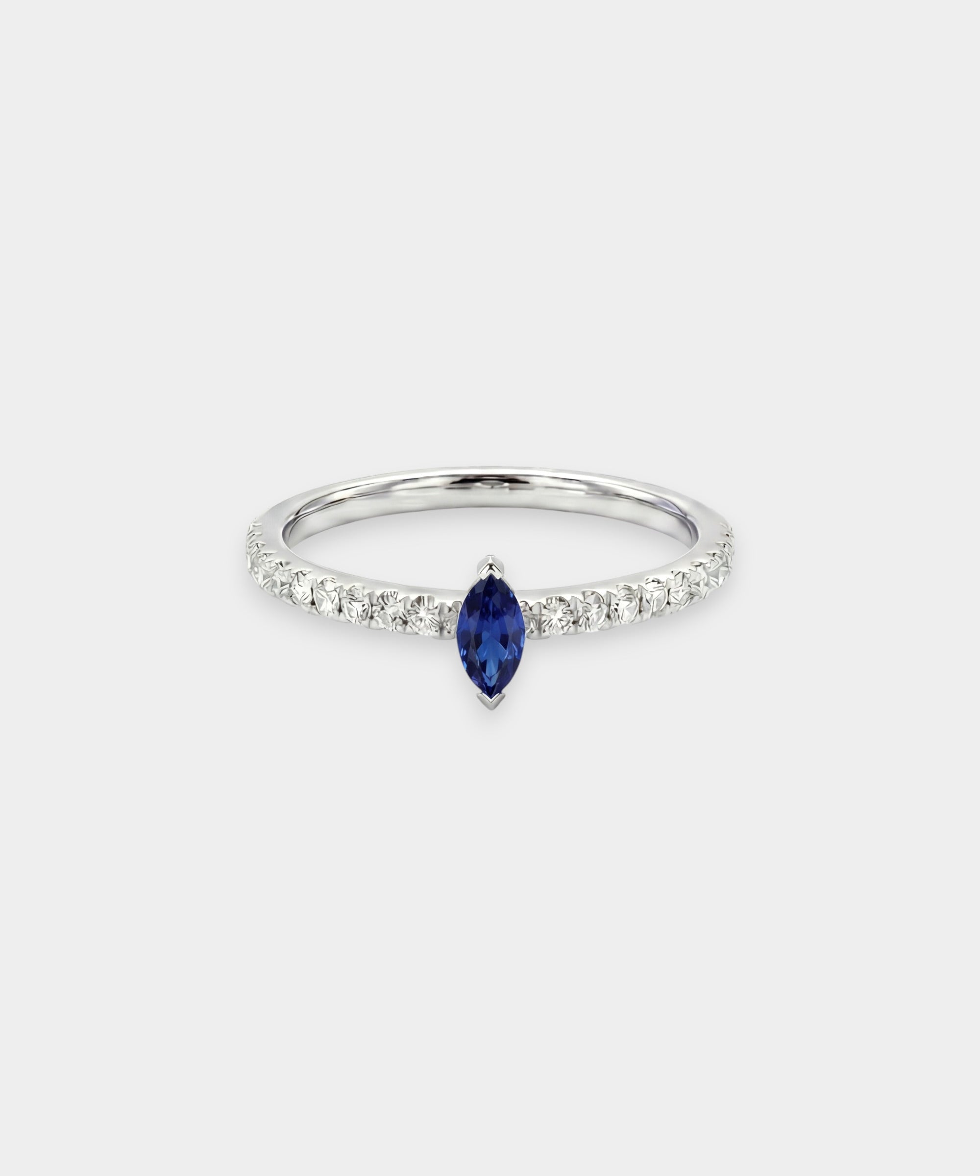 Ring with a blue sapphire and diamond accents on a light gray background