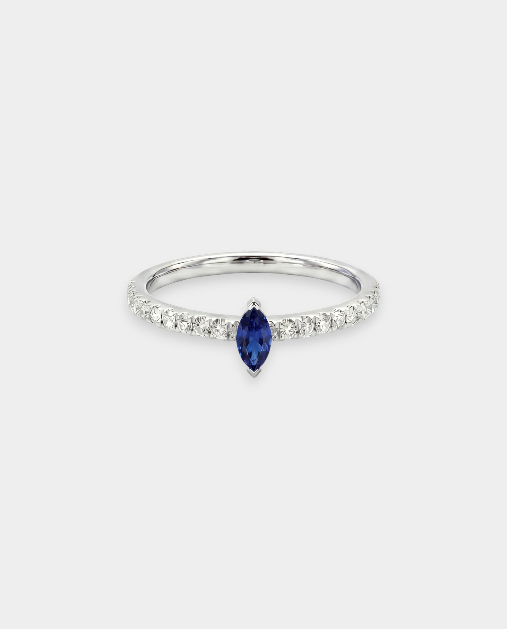 Ring with a blue sapphire and diamond accents on a light gray background