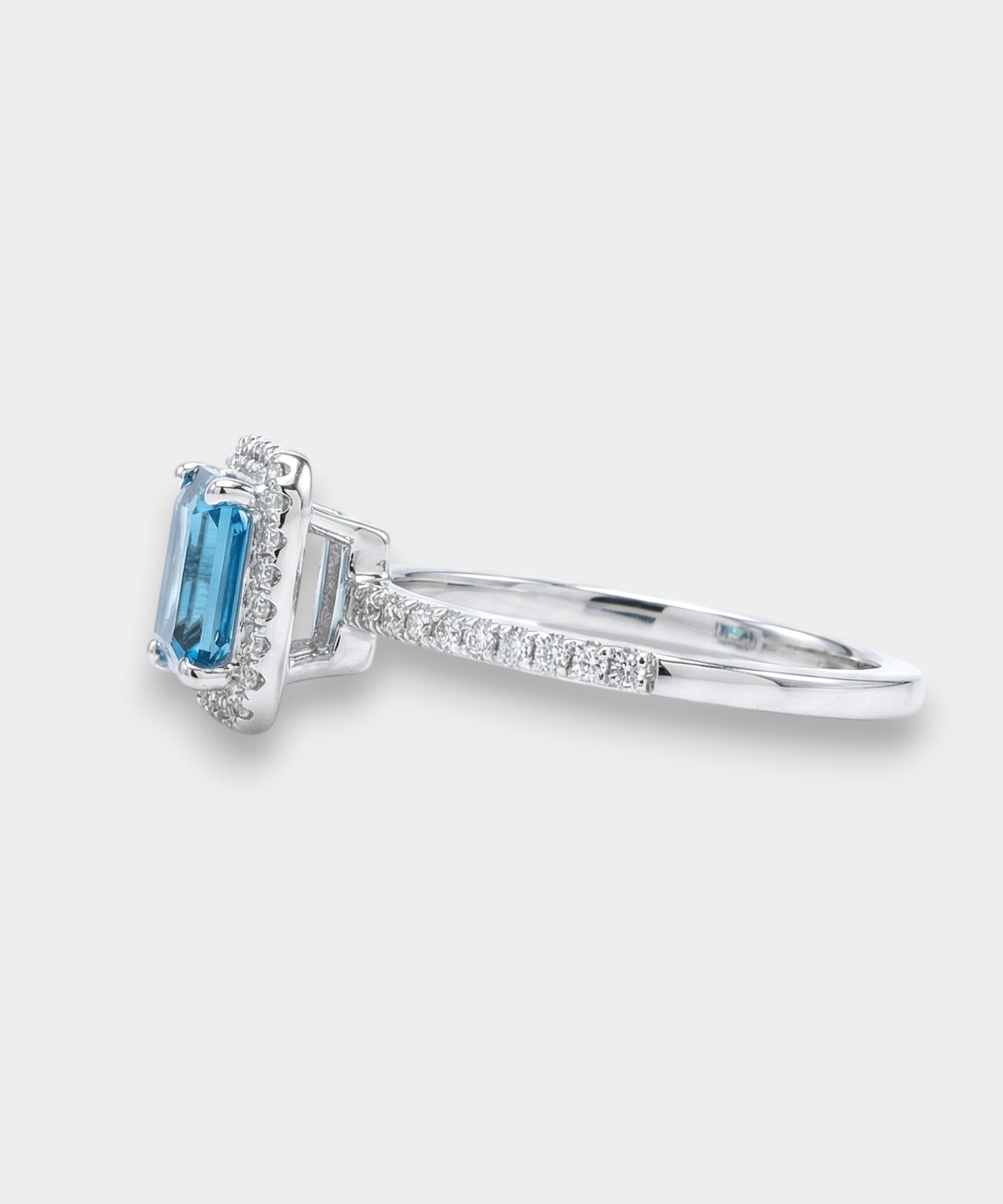 Ring with a topaz and diamond accents on a white background side view 