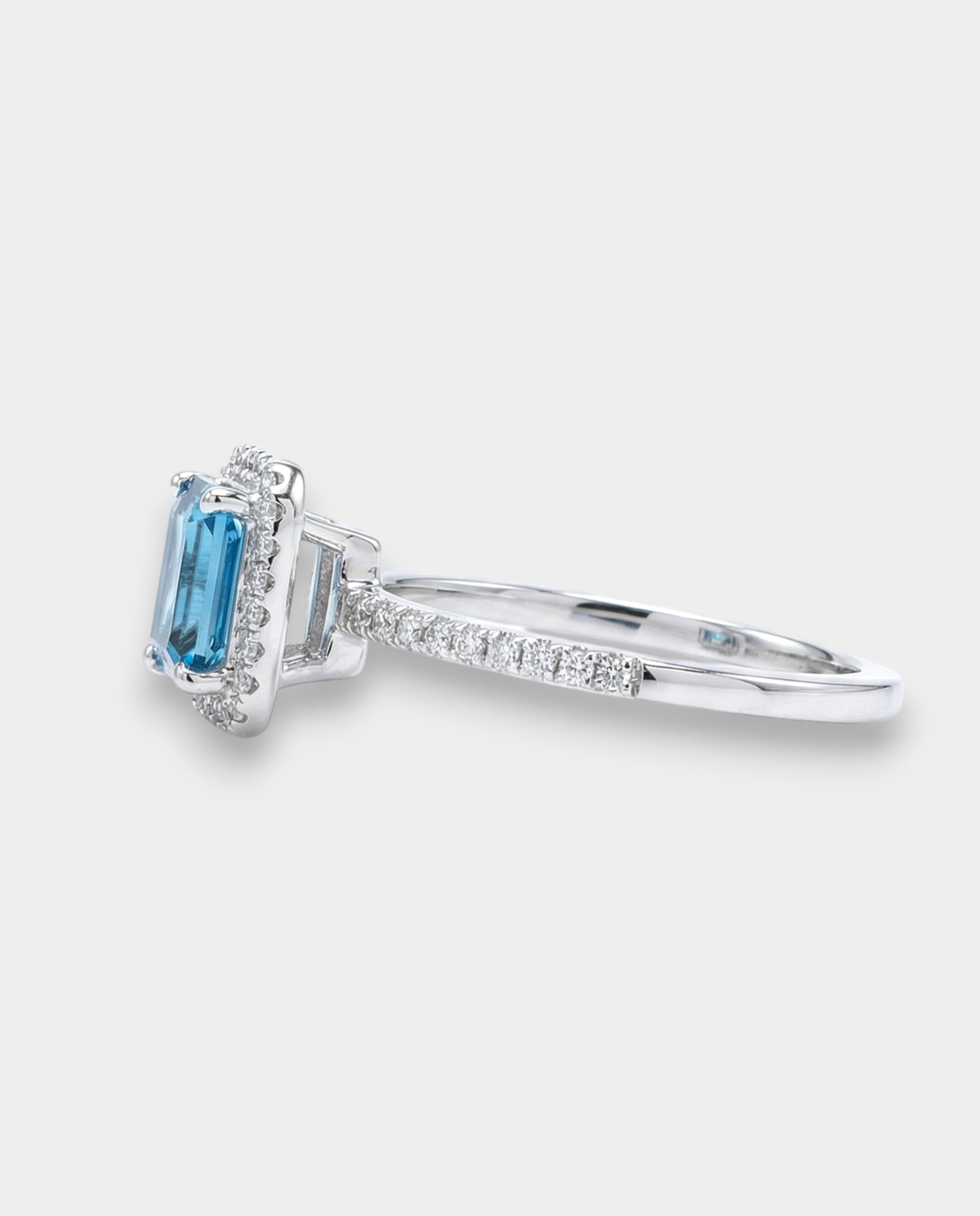 Ring with a topaz and diamond accents on a white background side view 