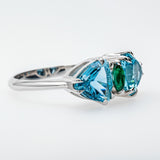 Silver ring with blue and green gemstones on a white background