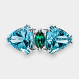 A ring with blue and green gemstones on a light gray background