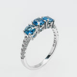 White gold ring with three sapphires on a light gray background