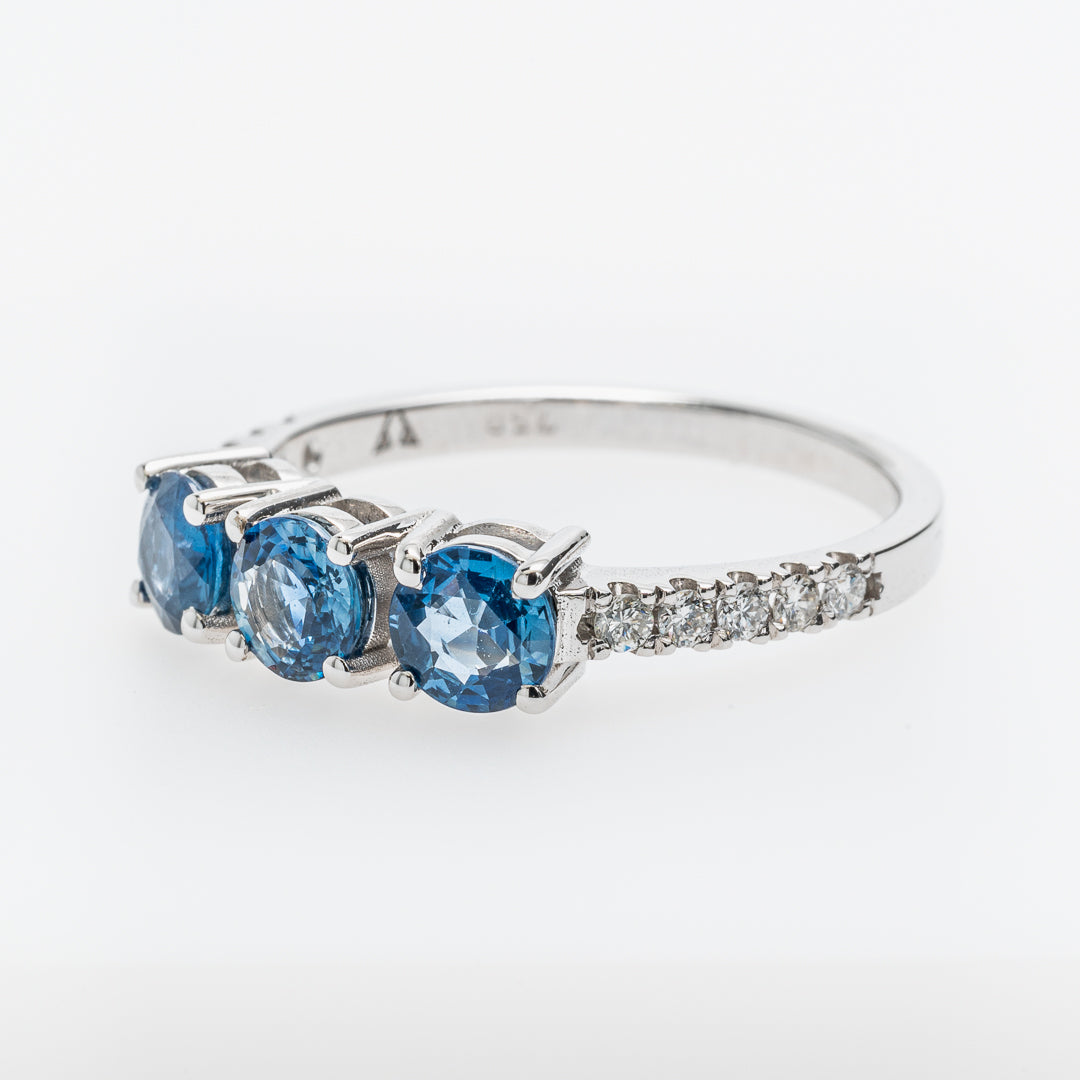 White gold ring with sapphires and small diamonds on a white background