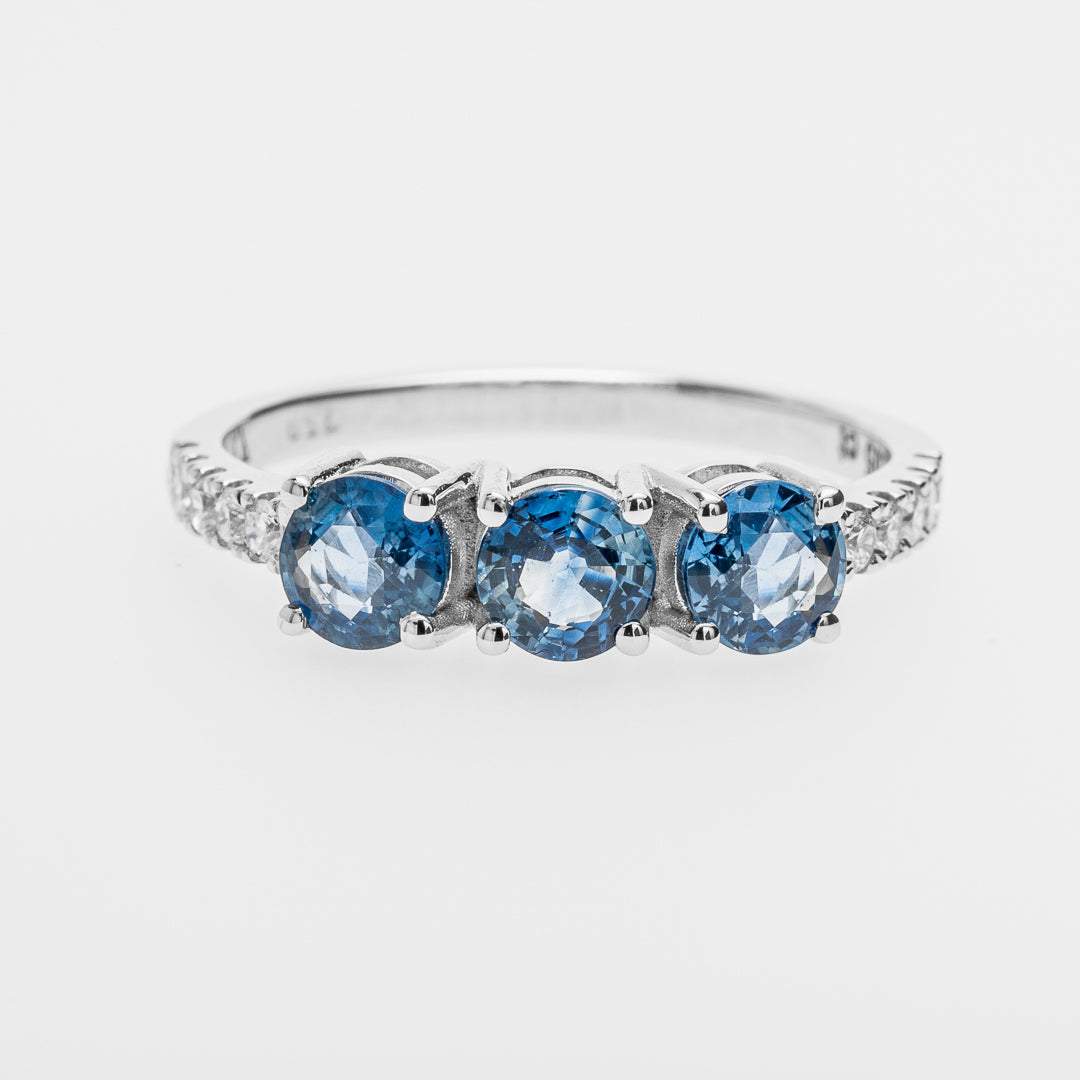 White gold ring with three sapphires on a white background