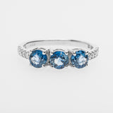 White gold ring with three sapphires on a white background