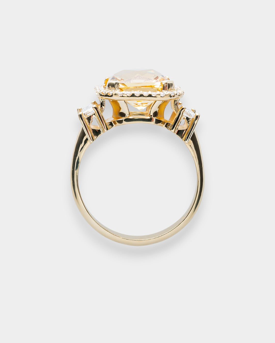 Gold ring with a large central beryl gemstone on a white background