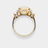 Gold ring with a large central beryl gemstone on a white background