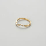Gold ring with chevron band and small diamonds on a light gray background