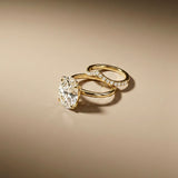 Two gold rings with diamond accents on a beige background