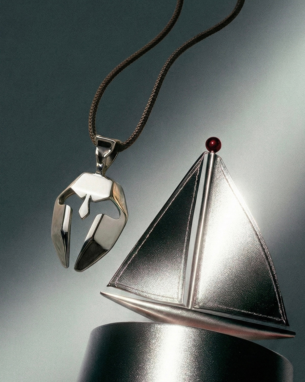 Silver spartan mask pendant with a sailboat 