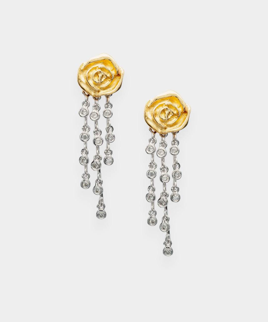 Gold rose-shaped earrings with diamond-like stones on a white background