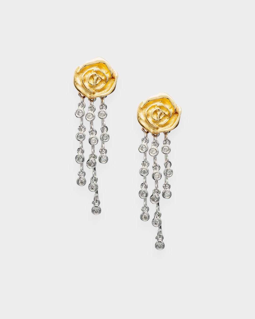 Gold rose-shaped earrings with diamond-like stones on a white background