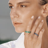 Close-up of a person wearing eternity rings with a blurred background