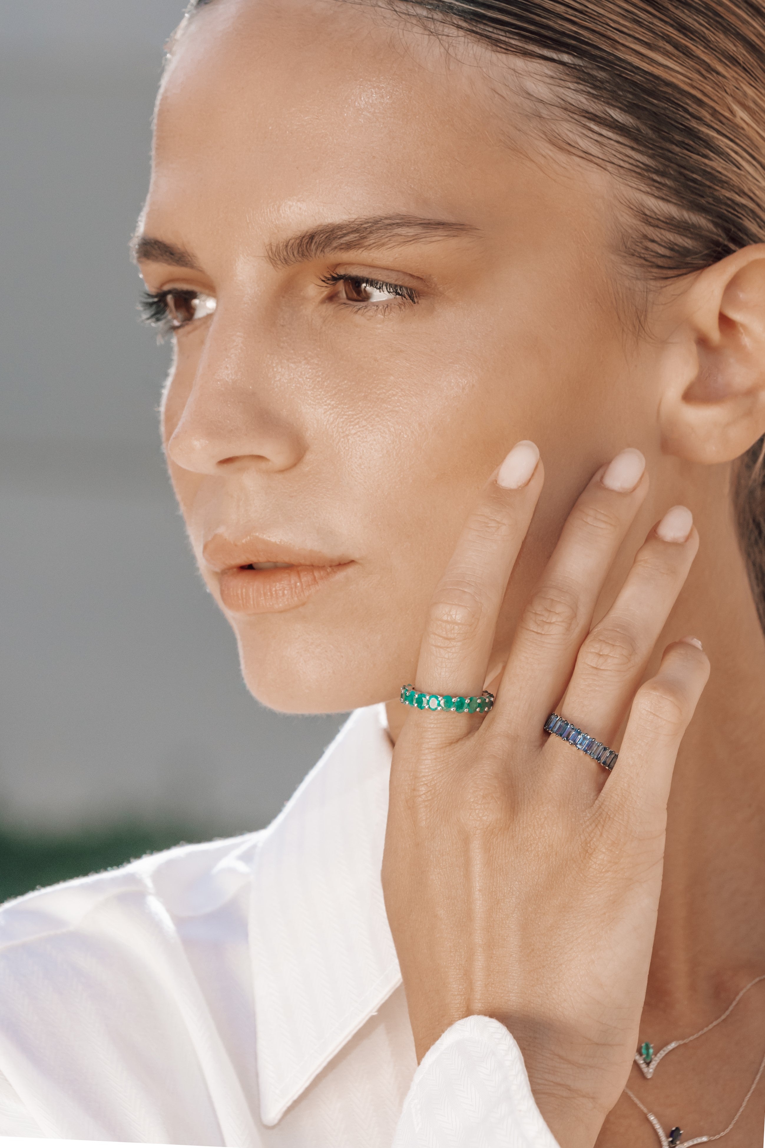 Close-up of a person wearing eternity rings with a blurred background