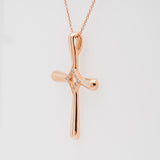 Rose gold cross pendant necklace on a light gray background