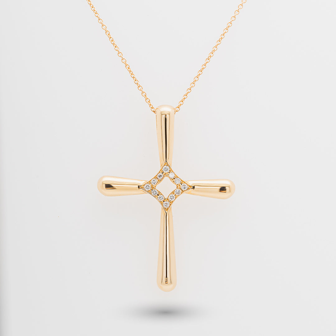 Gold cross necklace with diamonds on a light gray background
