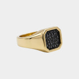 Gold ring with black diamonds on a light gray background