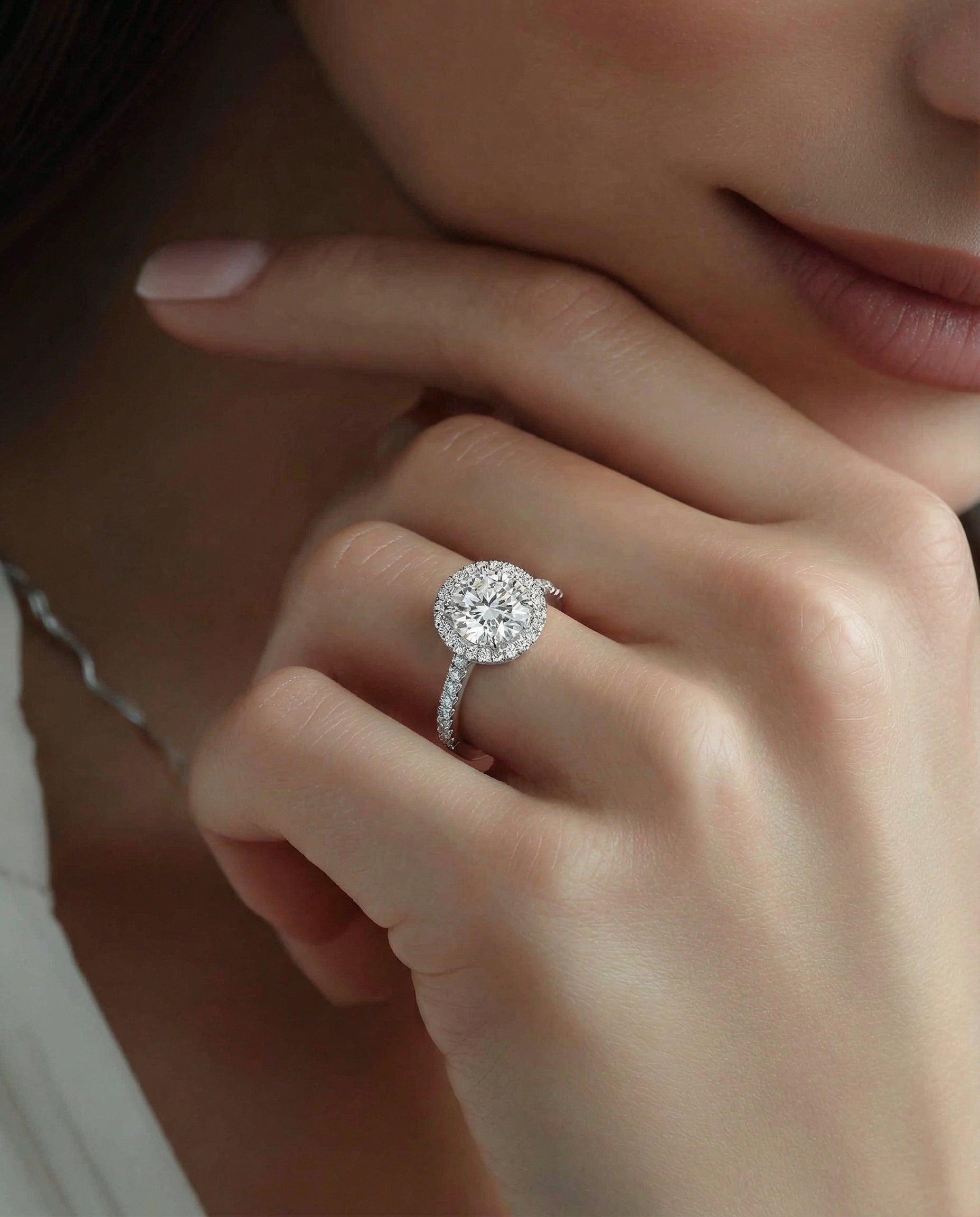 Close-up of a hand wearing a diamond ring with a soft focus background