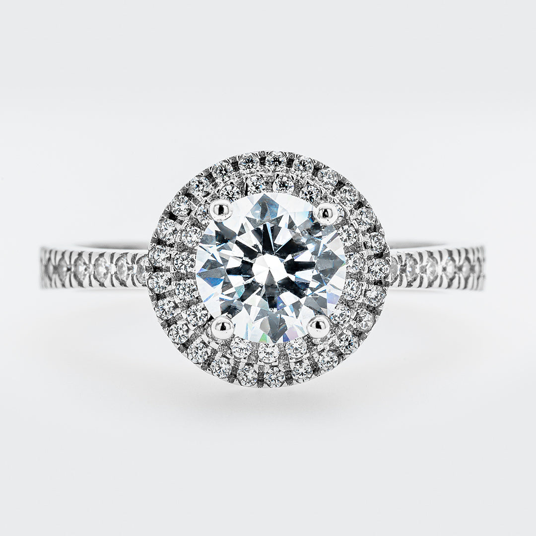 Diamond ring with a halo on a light gray background