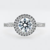 Diamond ring with a halo on a light gray background