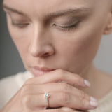 Woman wearing a diamond ring with a neutral background