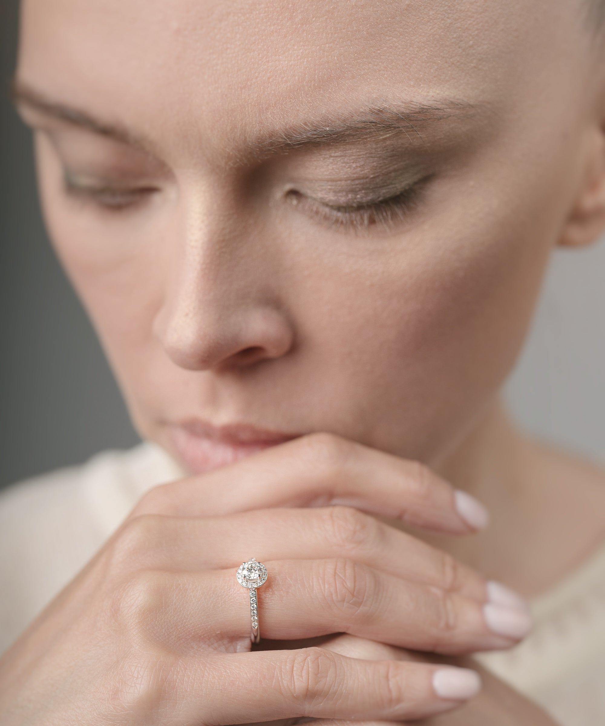 Woman wearing a diamond ring with a neutral background