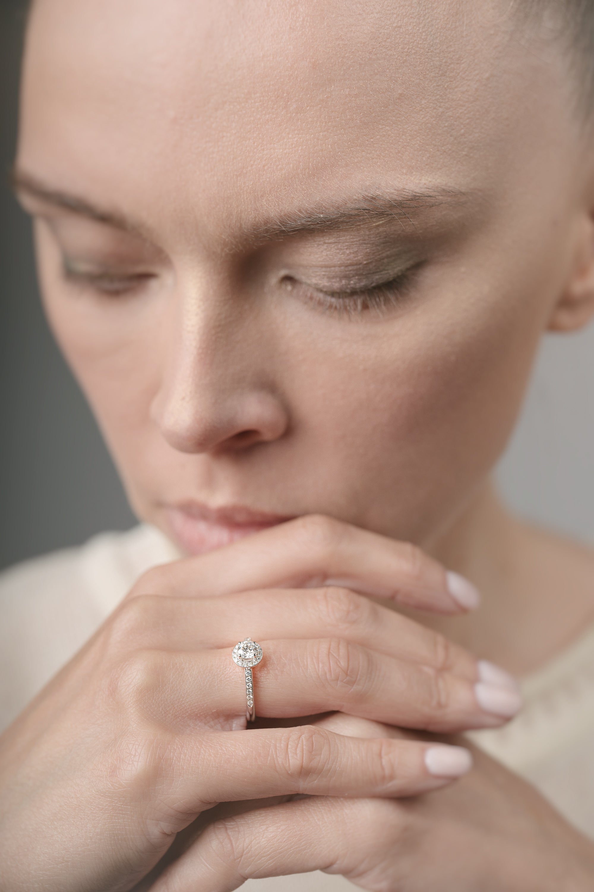 Woman wearing a diamond ring with a neutral background