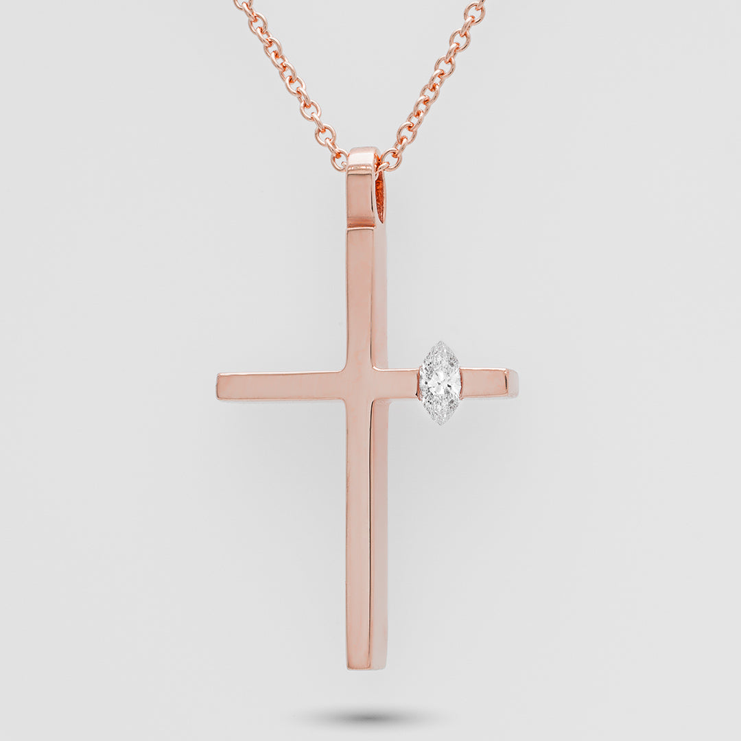 Rose gold cross pendant with a diamond on a light gray background