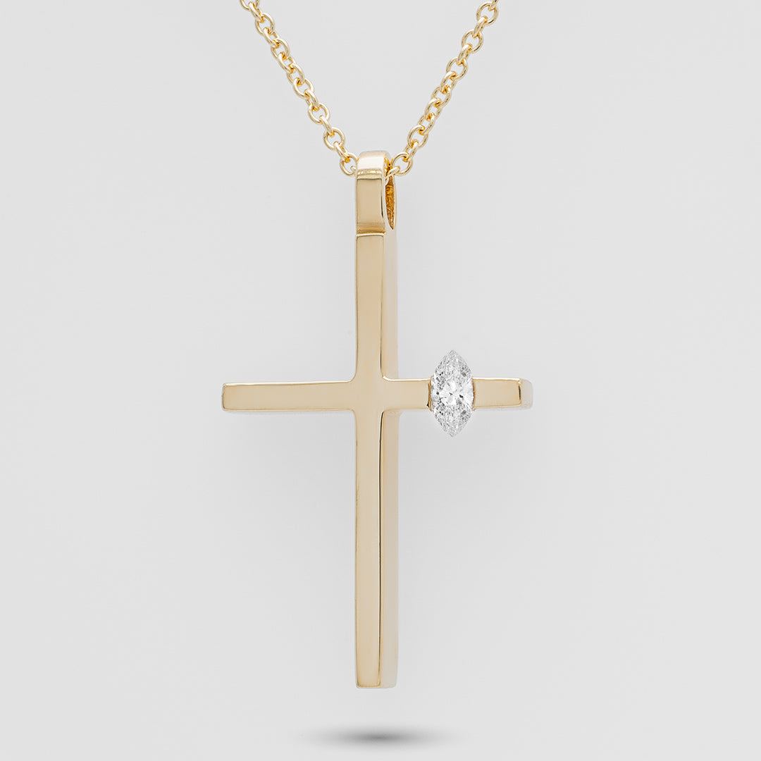 Gold cross pendant with a diamond on a light gray background