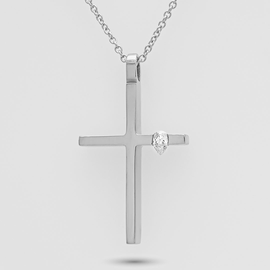 Silver cross pendant with a diamond on a light gray background