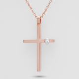 Rose gold cross necklace with a diamond on a light gray background