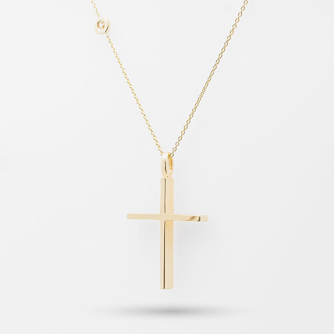 Gold cross necklace on a white background