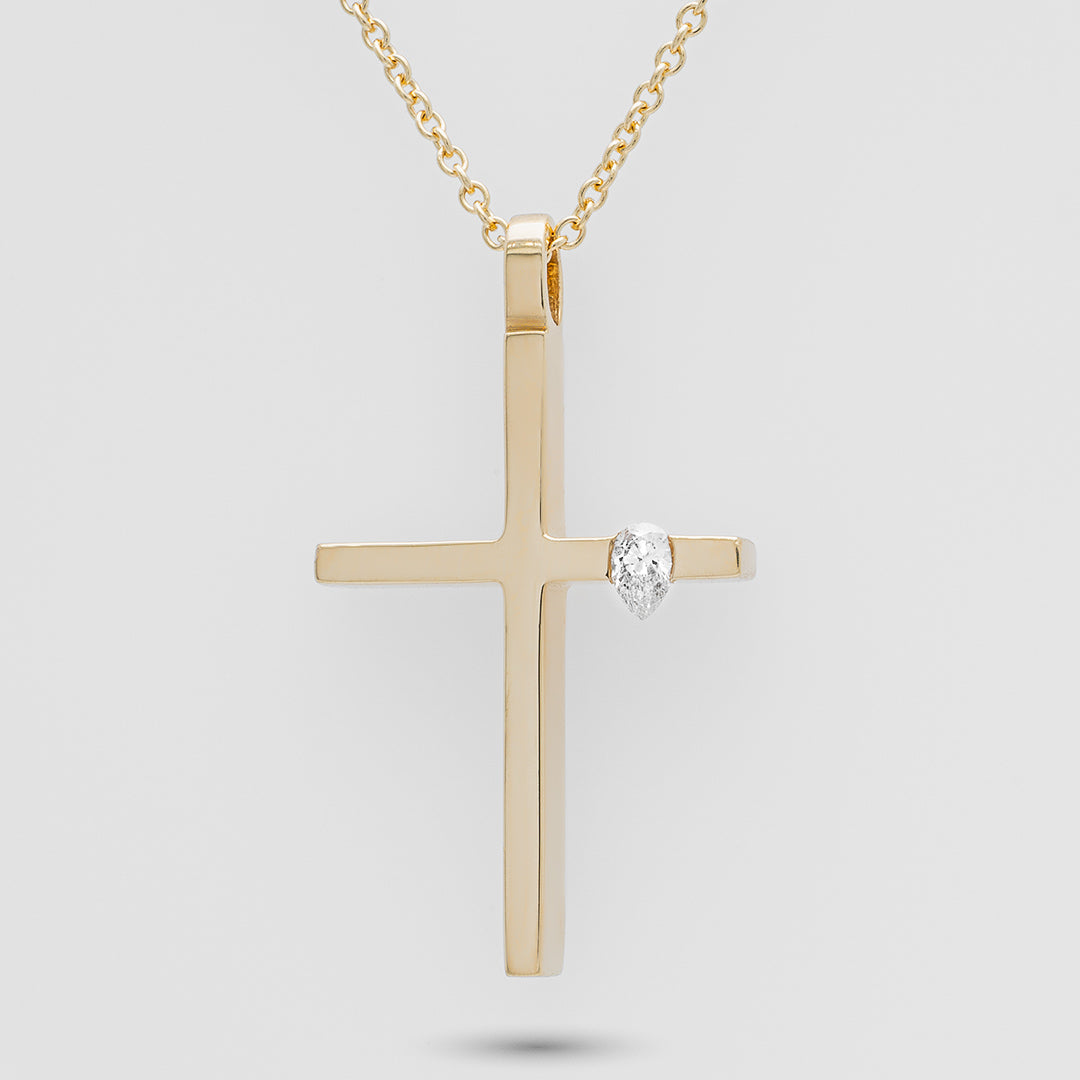Gold cross pendant with a diamond on a light gray background