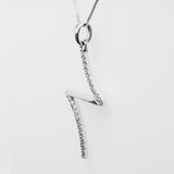 White gold necklace with a cross-like pendant on a white background