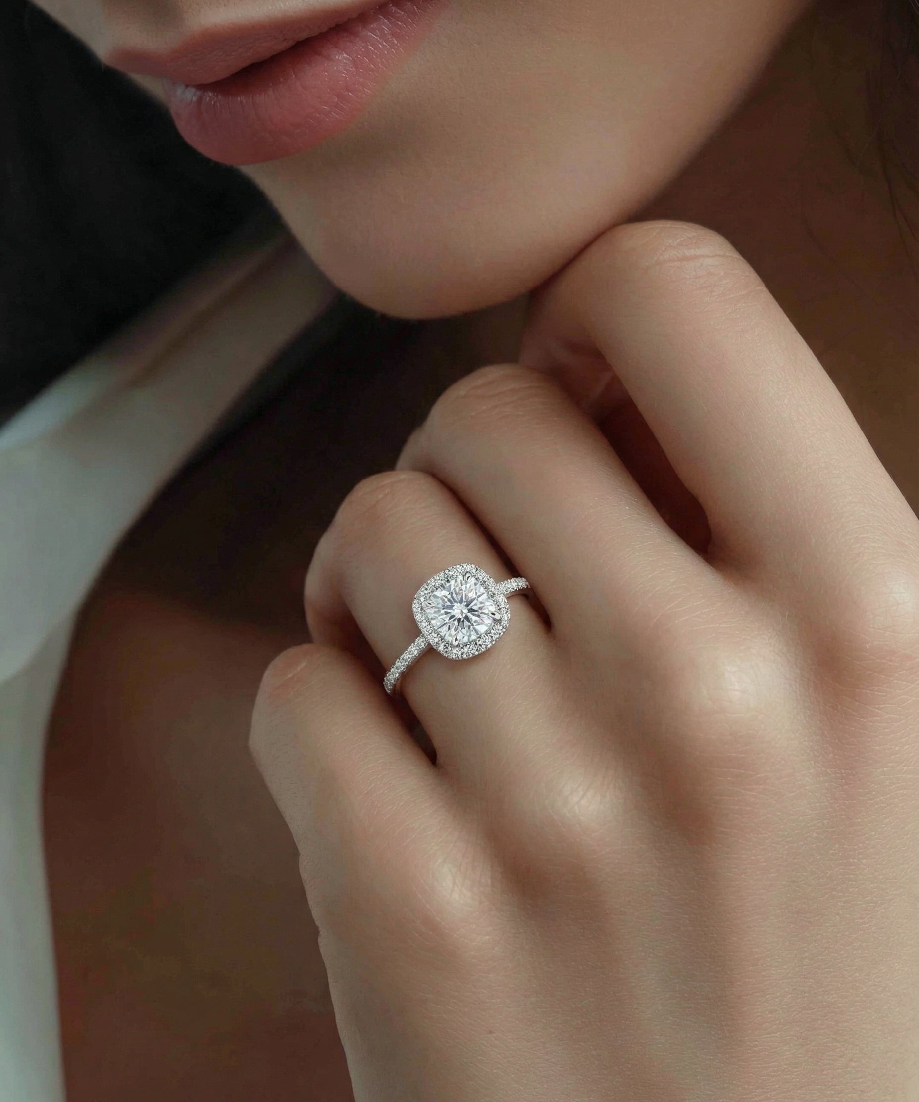 Close-up of the model's hand with a cushion-cut diamond engagement ring