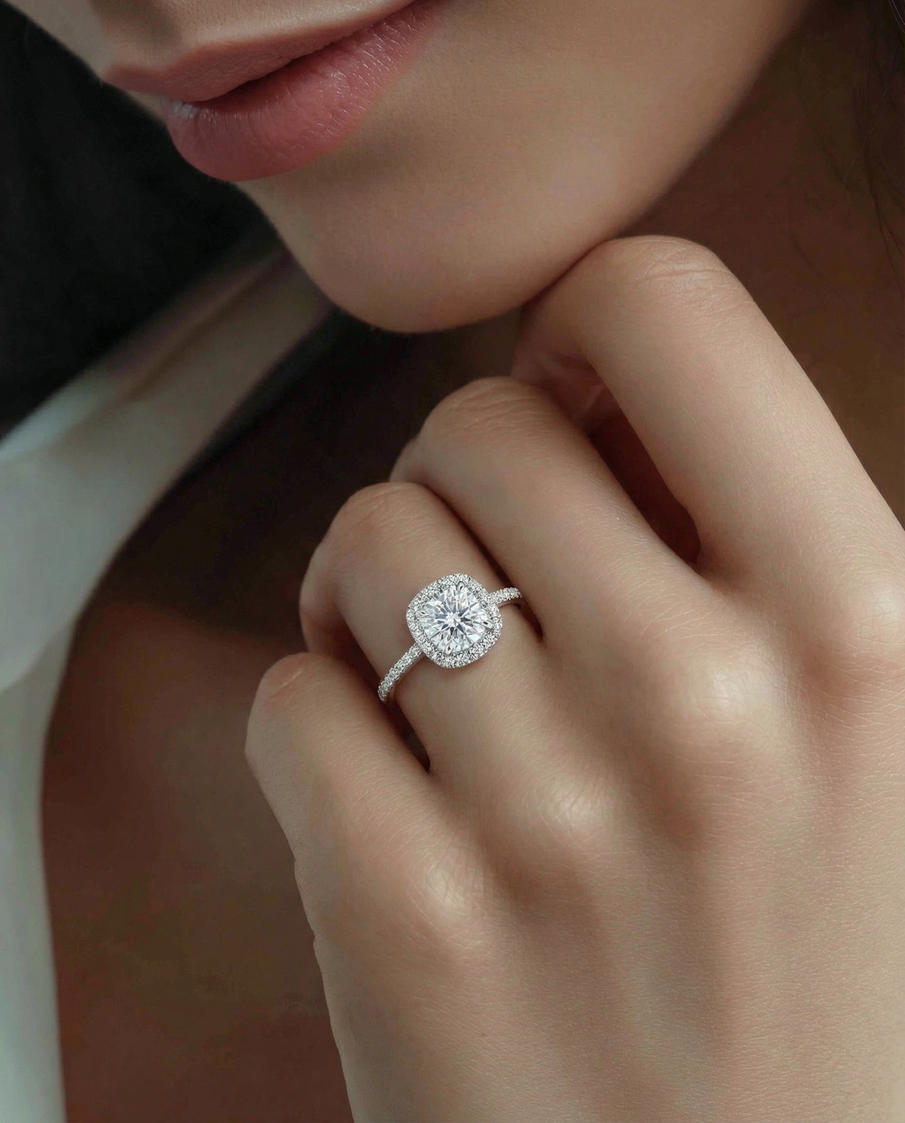 Close-up of the model's hand with a cushion-cut diamond engagement ring