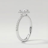 Diamond ring with a halo and side stones on a light gray background