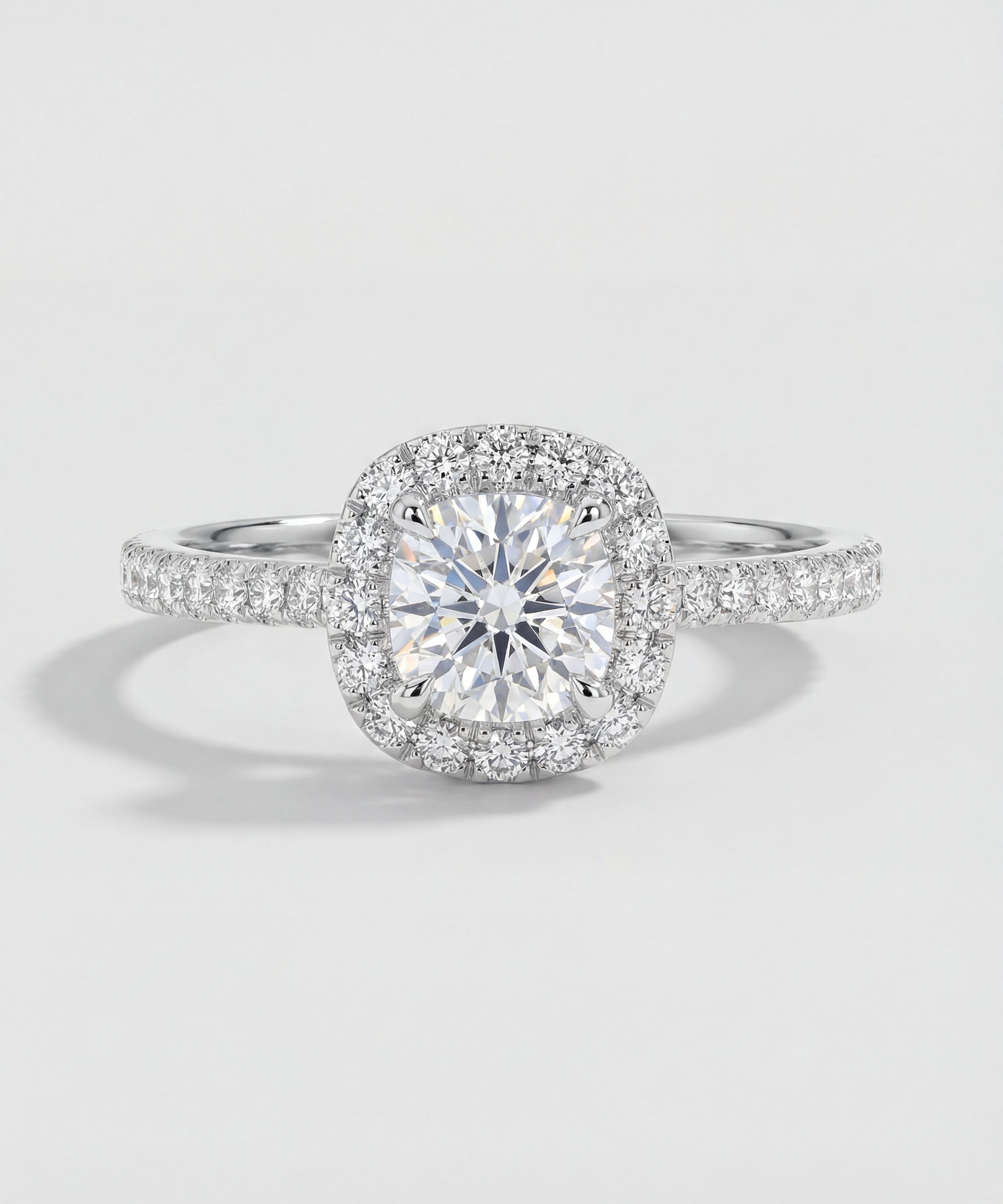 Diamond ring with a halo on a light gray background