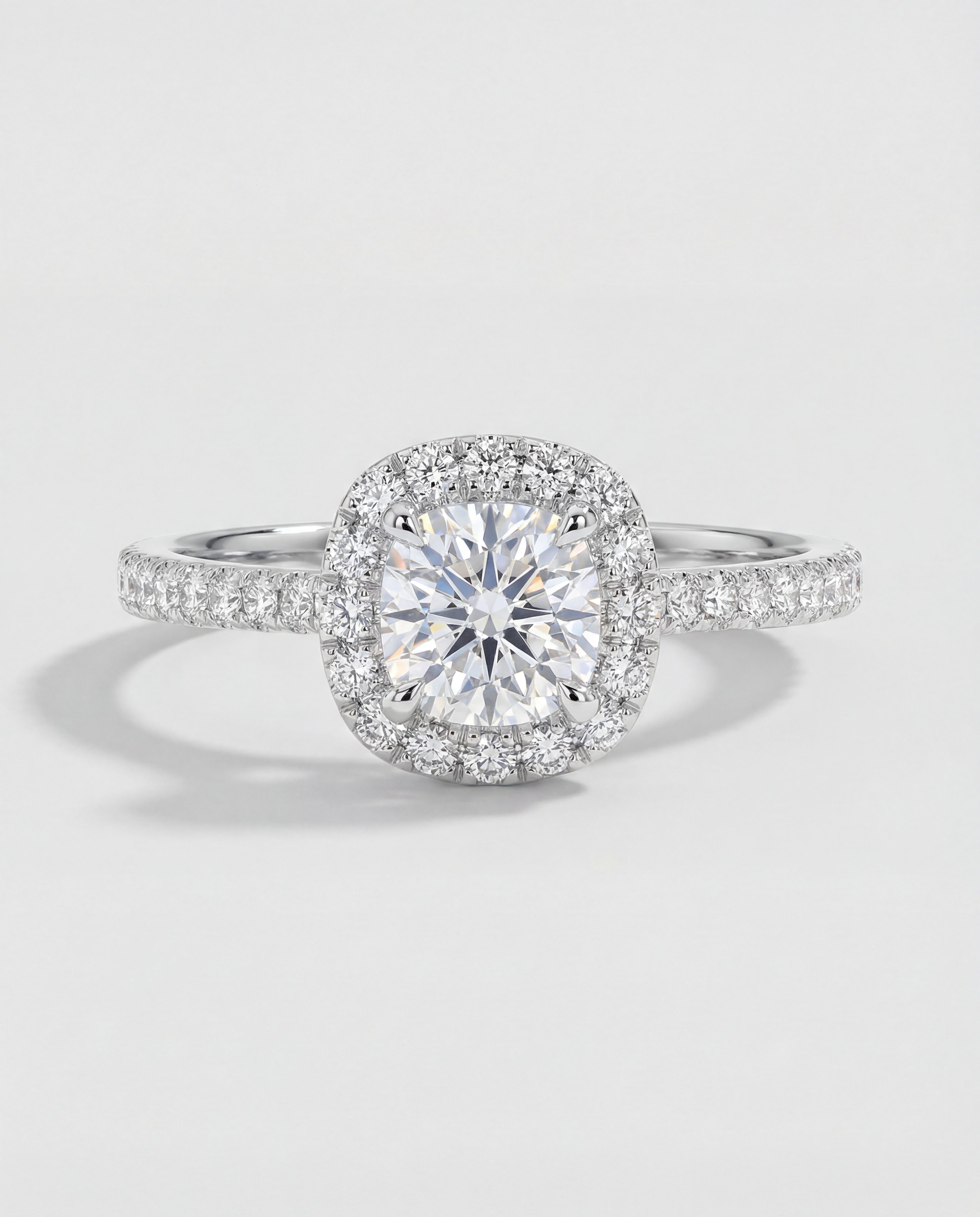 Diamond ring with a halo on a light gray background