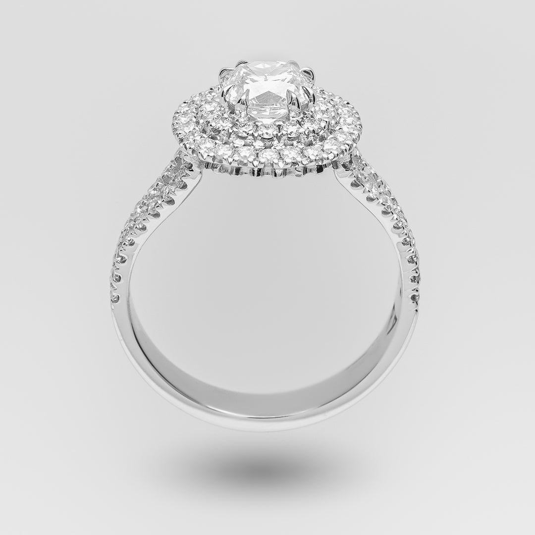 Diamond ring with a halo on a light gray background