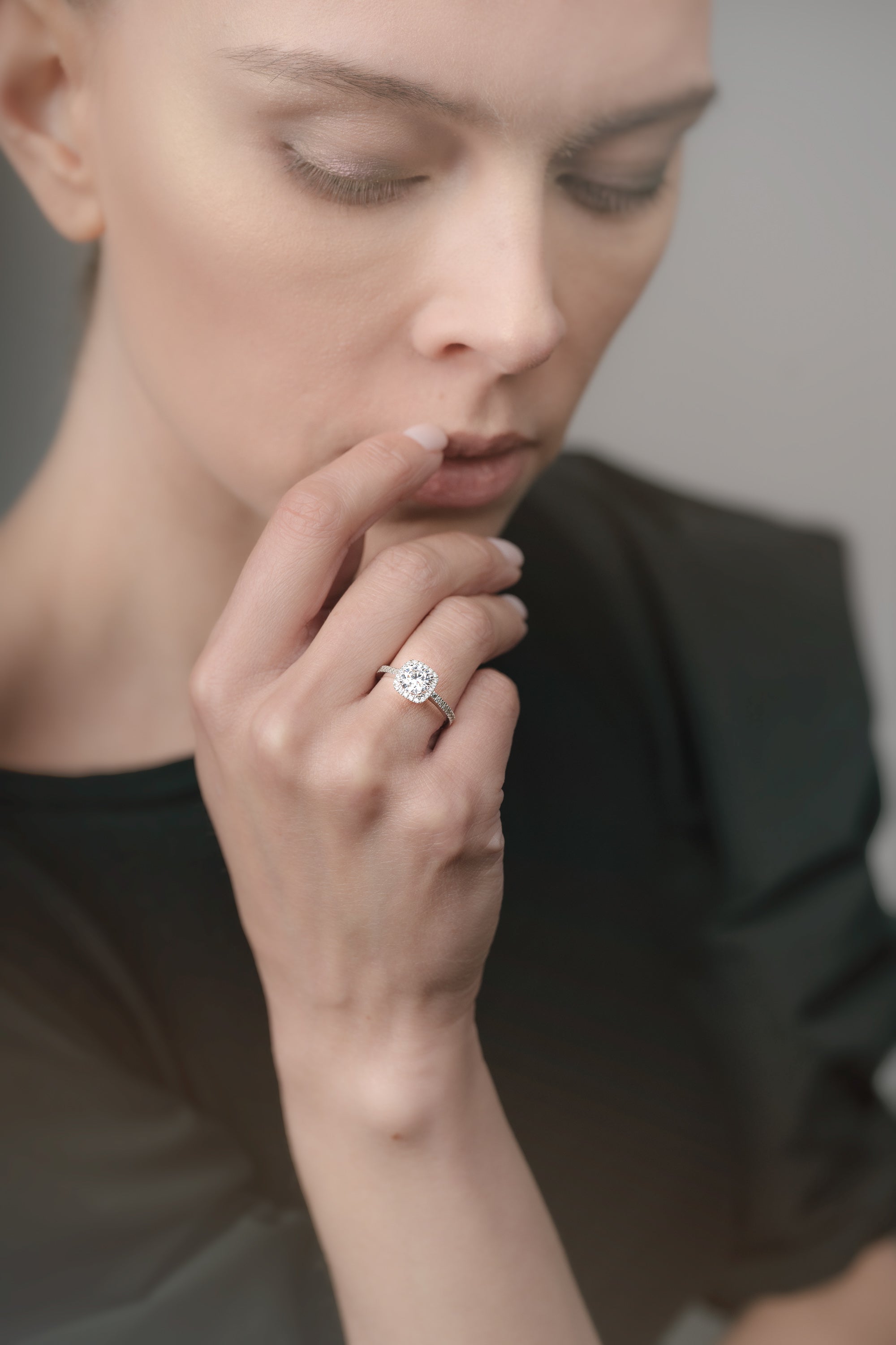Close-up of a woman's hand wearing a diamond ring with a blurred background
