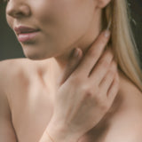 Woman wearing a gold triangle bracelet on her wrist